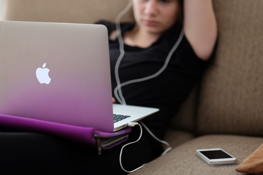 Woman using laptop with earphones