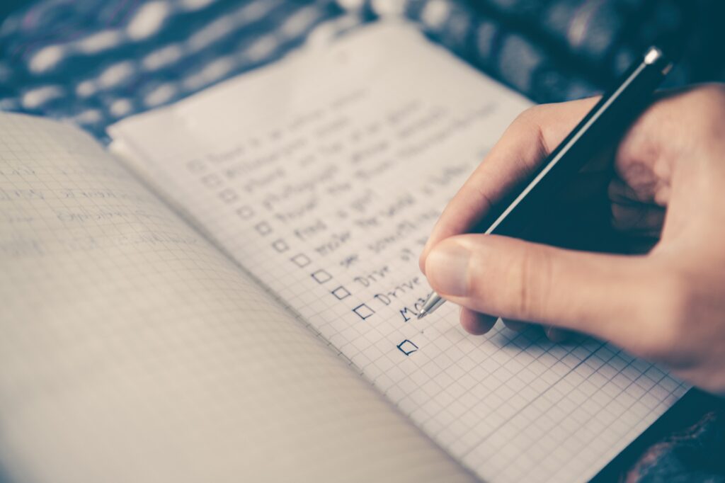 a notebook and a pen showing a checklist
