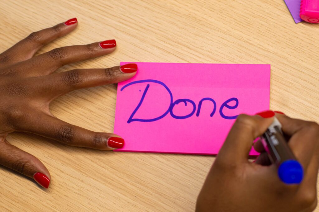 hands with the word "Done" on a stickie note 