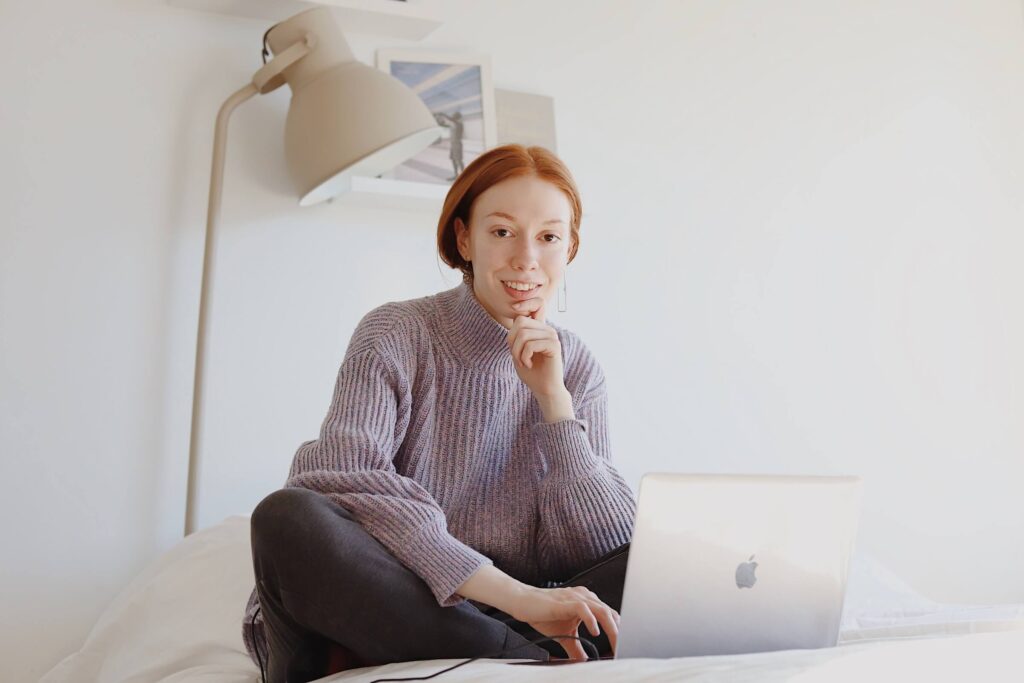 Woman working on laptop in bed