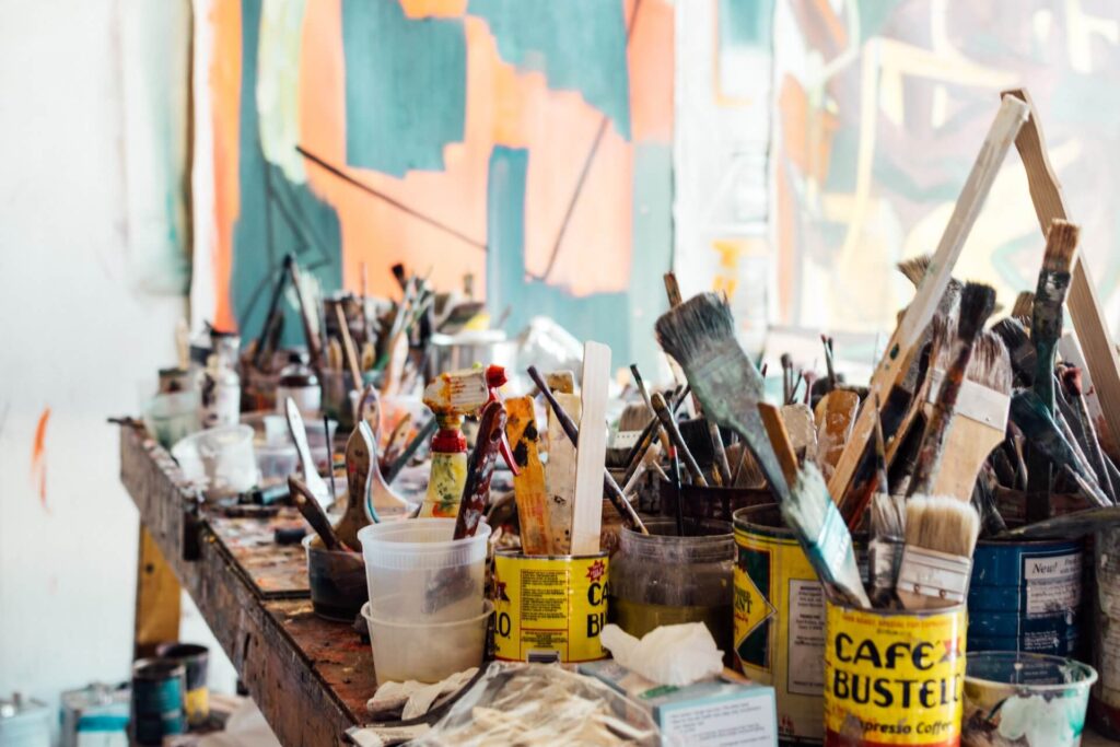 Artists tools, paint brushes in cans, rulers, sprays