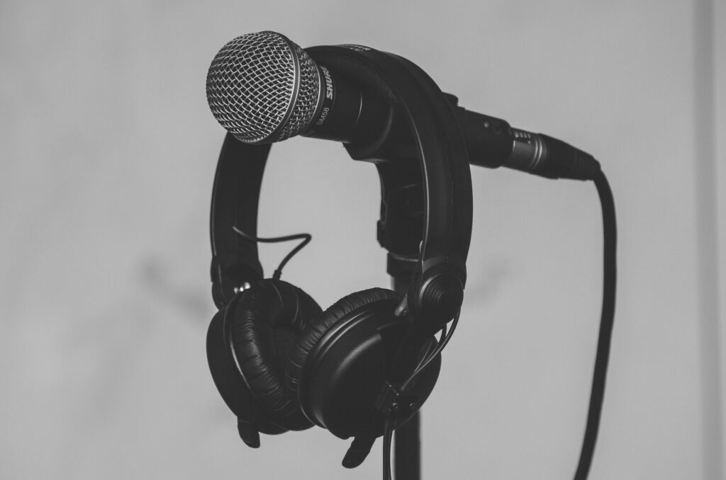 black and white earphones hanging on a microphone stand