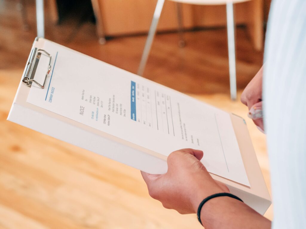 Person Holding White Printer Paper Invoice

