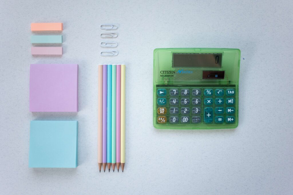 Calculator with pencils, sticky notes, and paper clips 