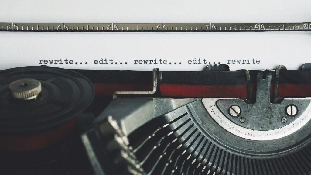 paper on typewriter with words rewrite and edit printed on it