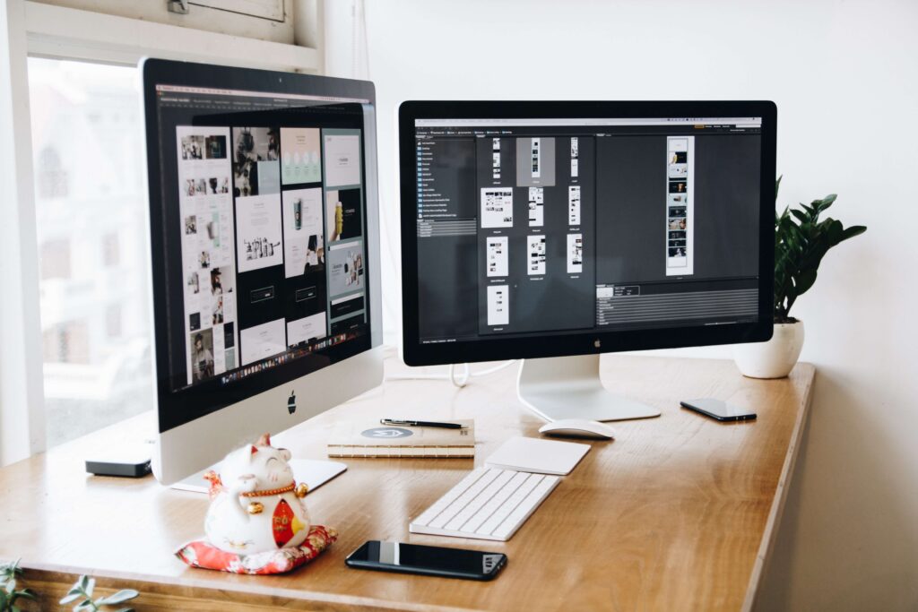 two imac computers on table