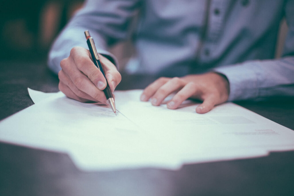 Papers being signed with a pen