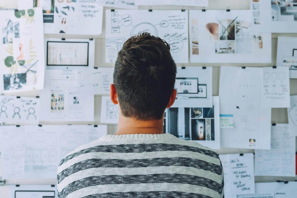 Man looking at board with images, plans