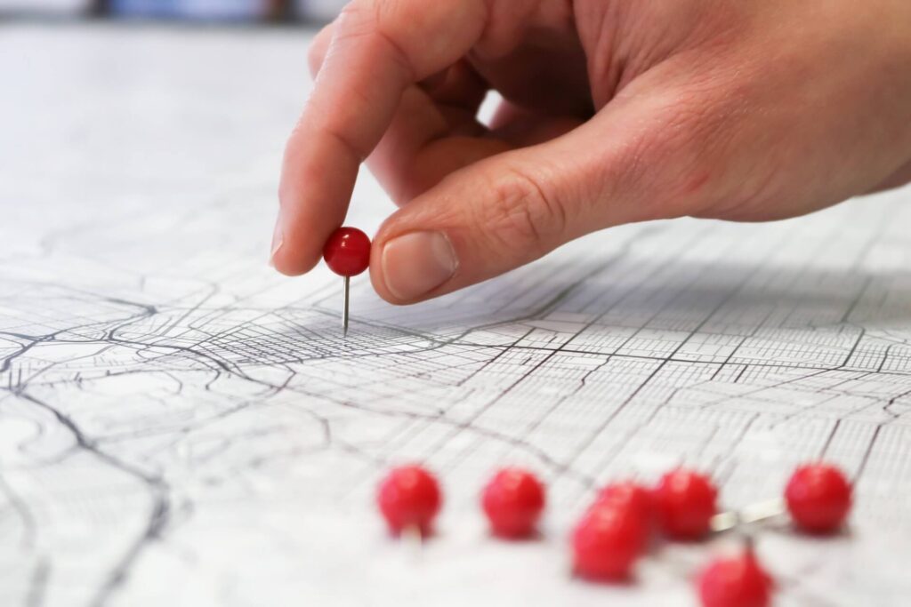 Hand pinning a tack on a map