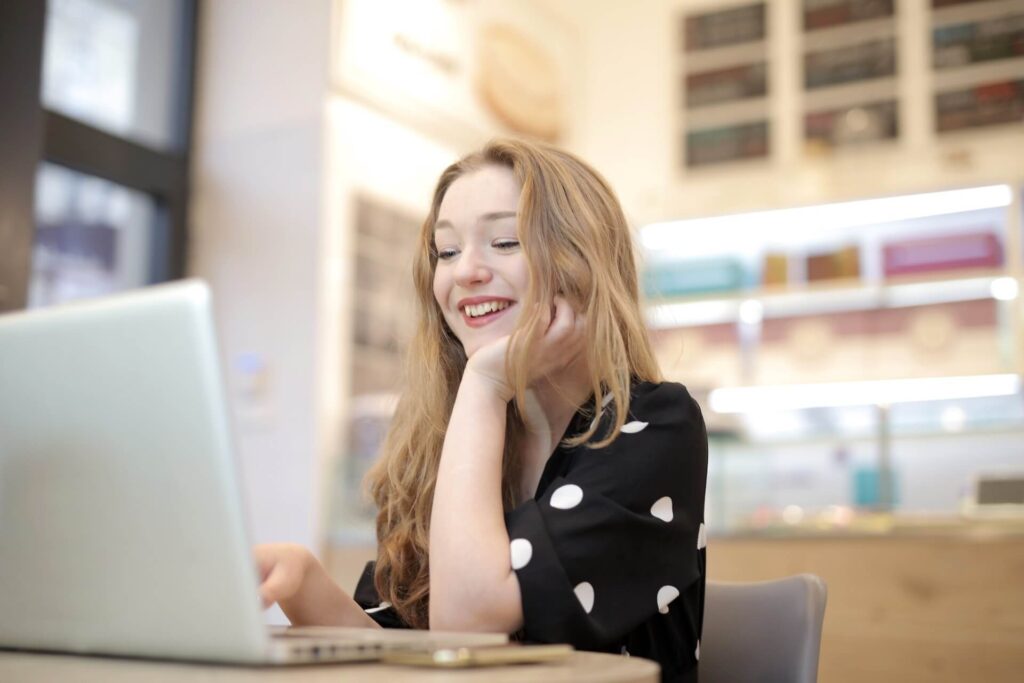 Woman smiling, using a laptop