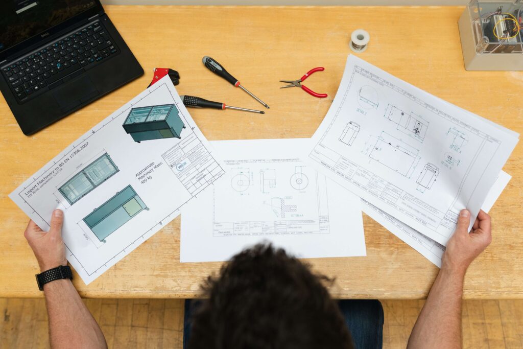 man holding engineer documents on table 