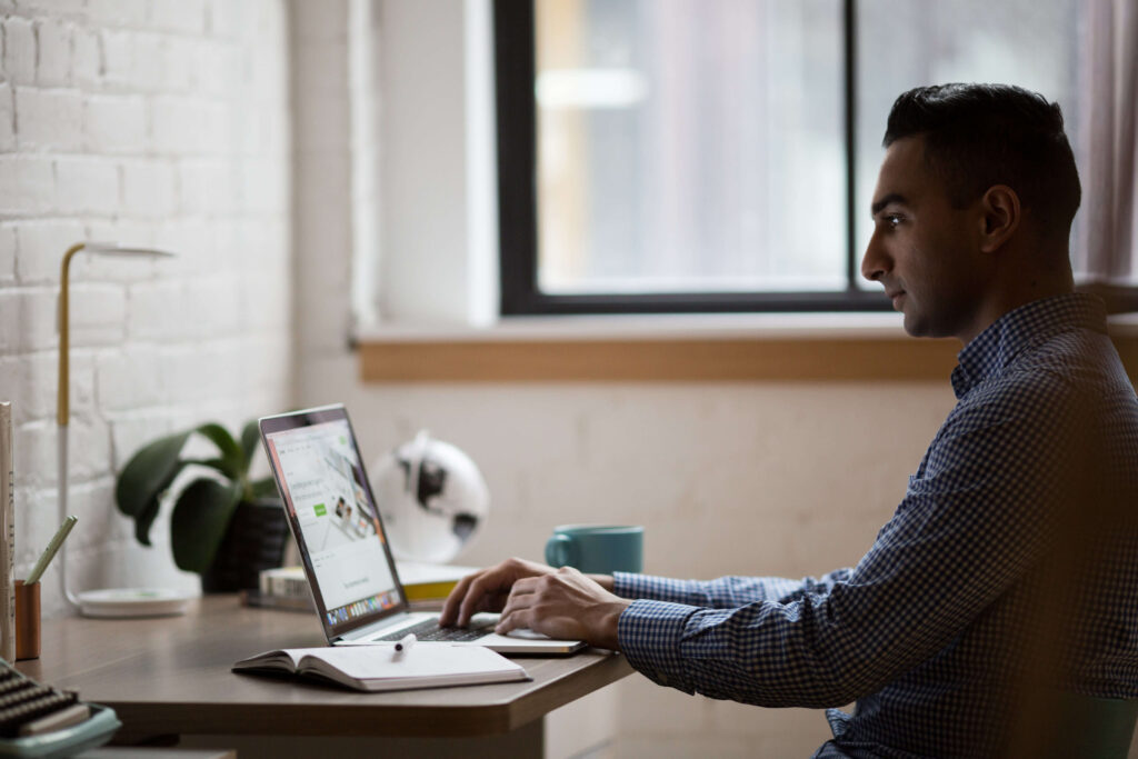 man working on a table with laptop