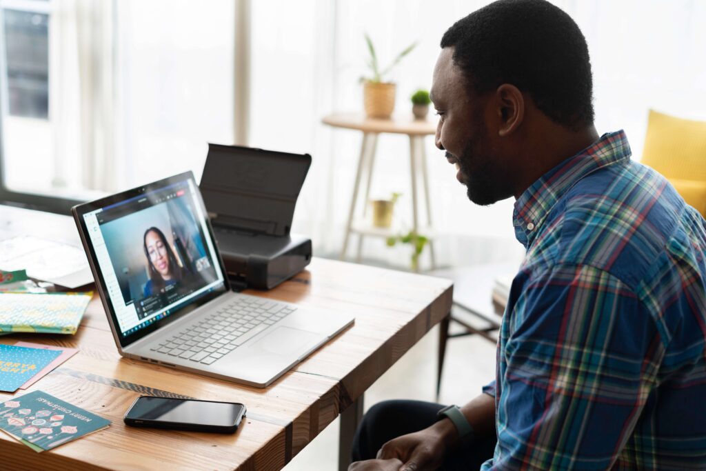 man watching a woman talking on  laptop