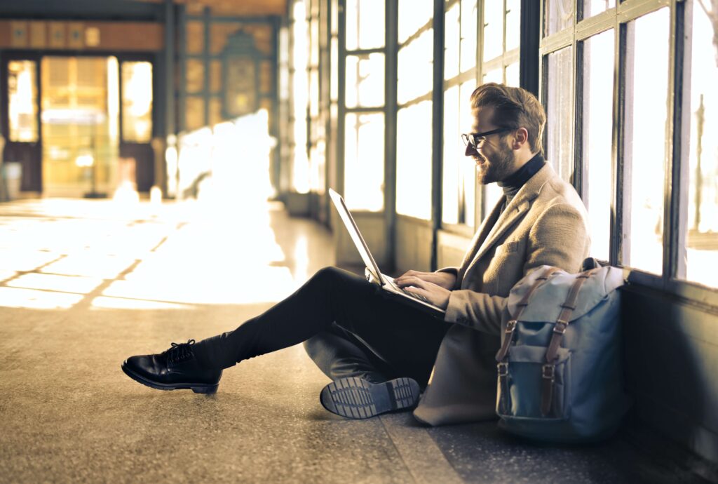 man sitting on the floor typing on laptop