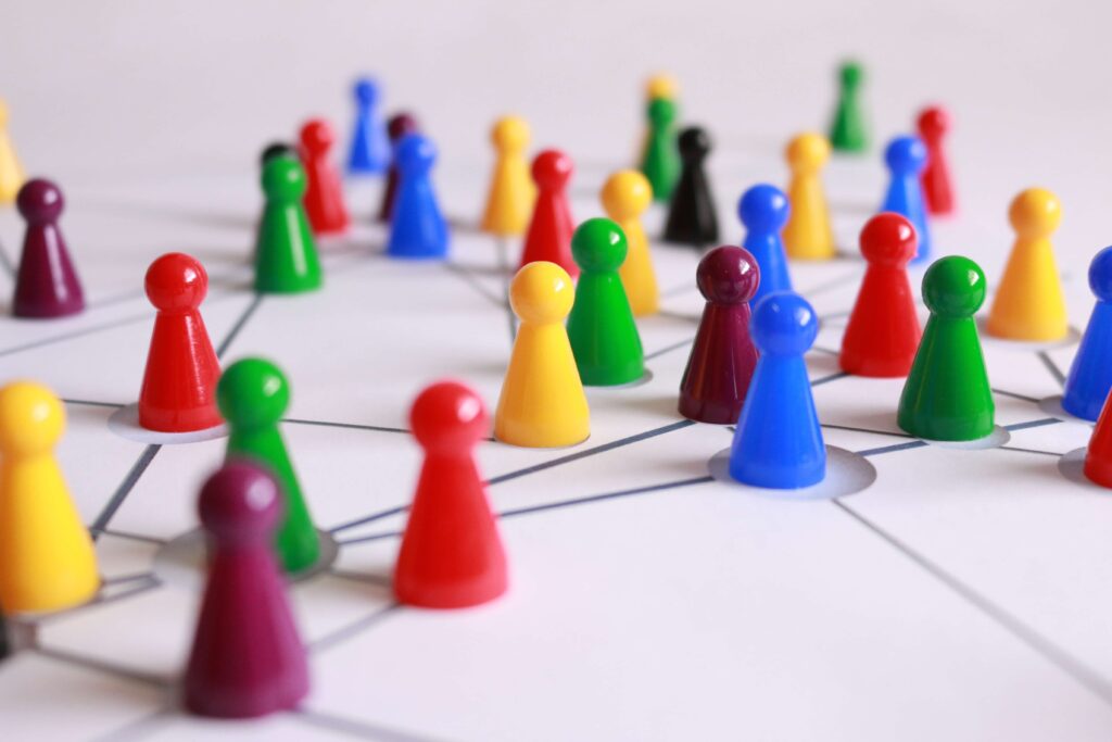 plastic game pieces on a white board connected with lines