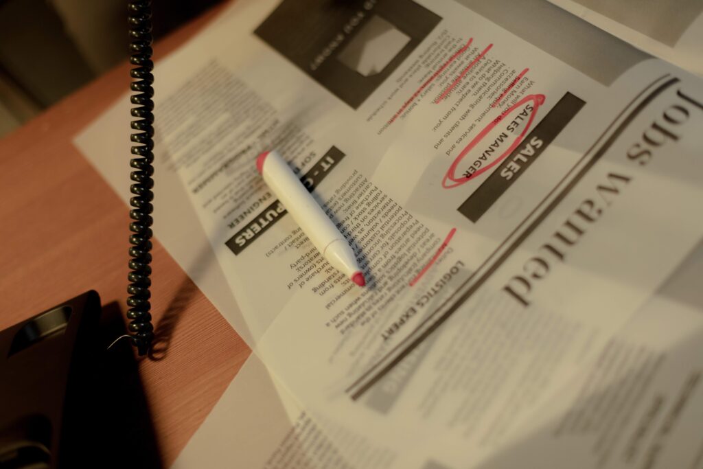 classified ads page with marker and part of a telephone
