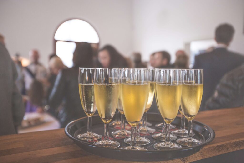 champagne glasses on a tray with blurred guests on the background