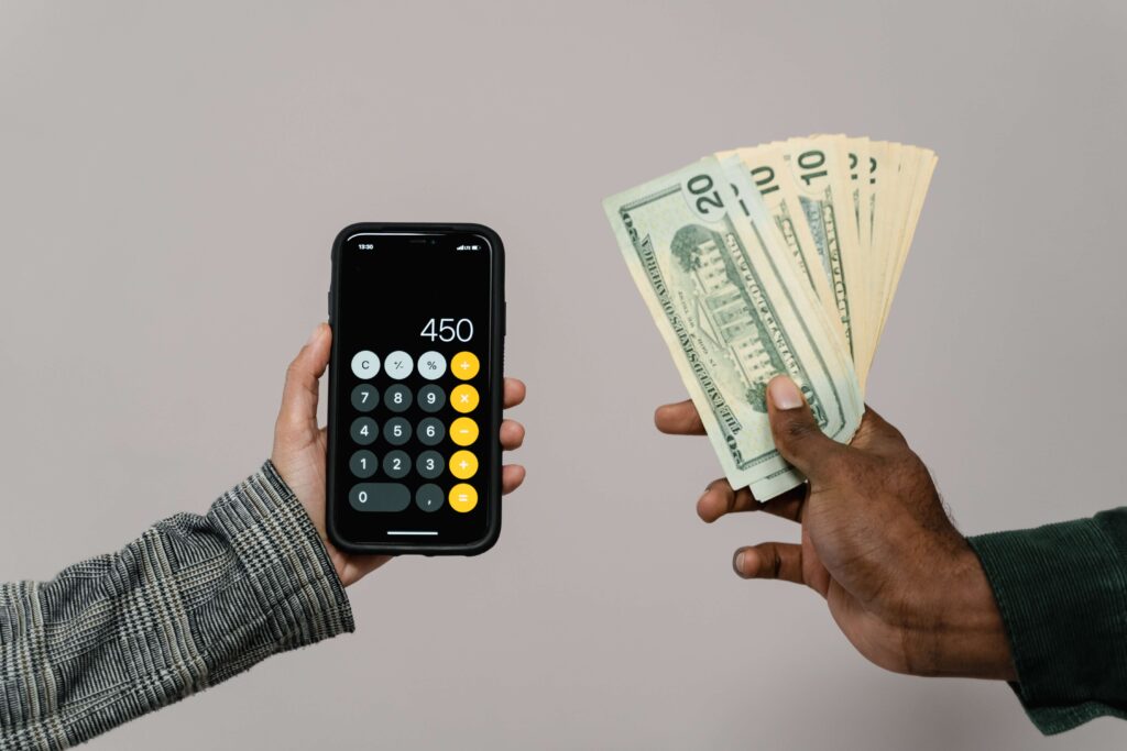 calculator on phone and cash help by 2 different people