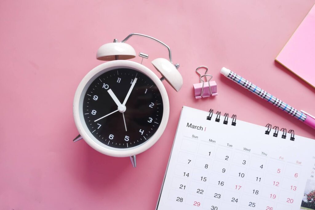 A clock, a calendar, a bull clip, a pen, and a notepad.