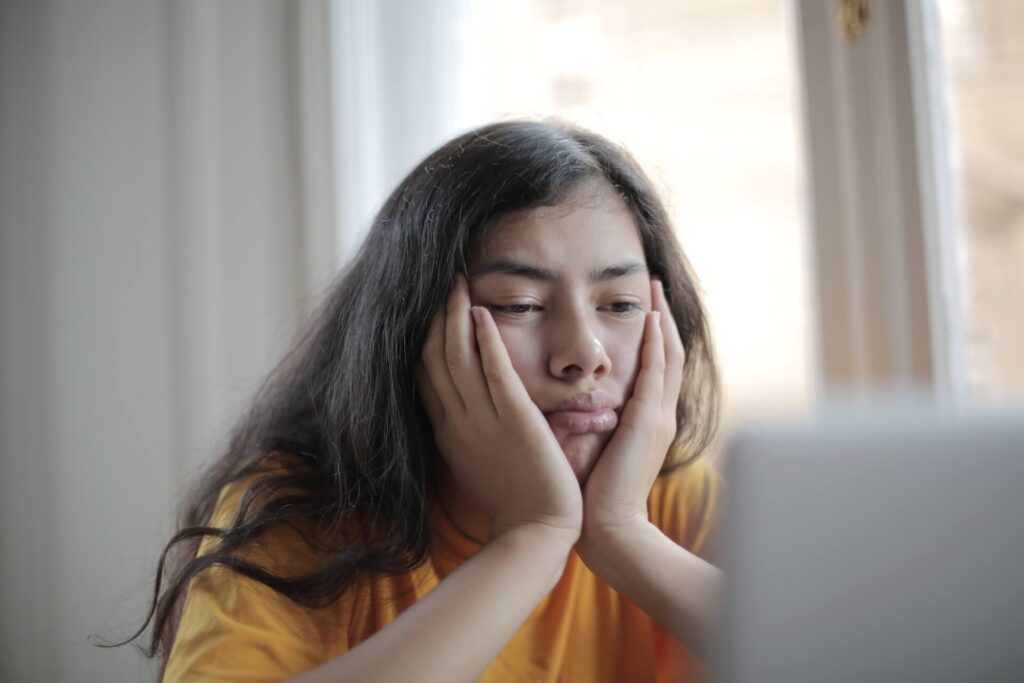 Woman sad, lookin at a laptop