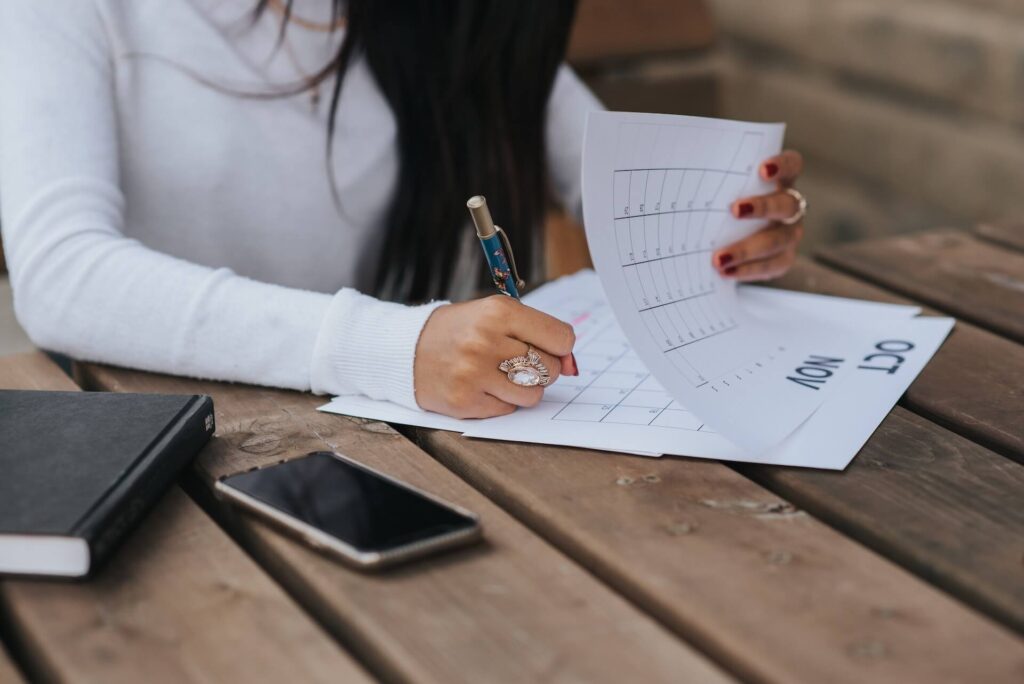 Woman writing on a calendar on the month of October