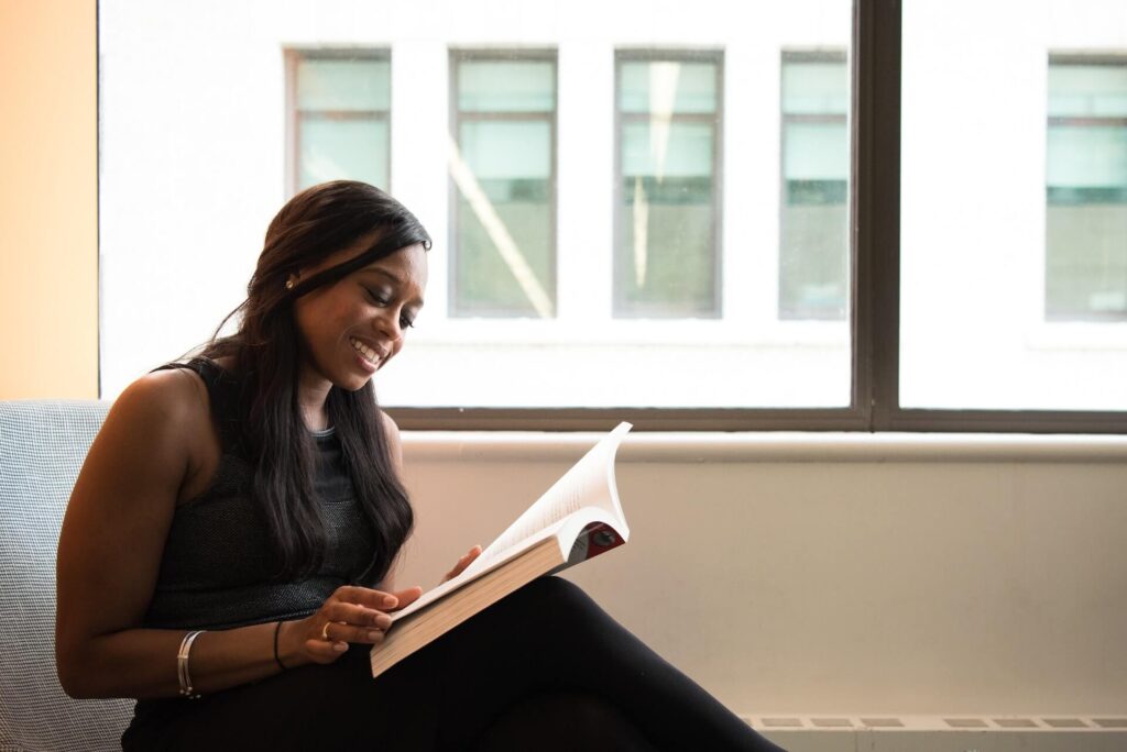 Woman smiling while reading a book