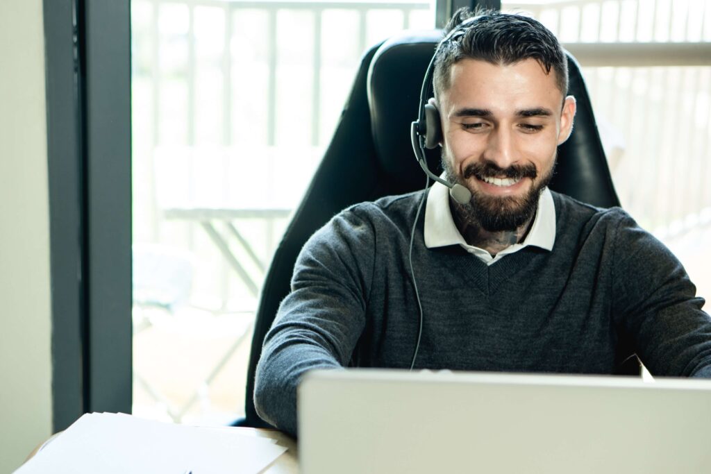 man wearing headphones looking at laptop
