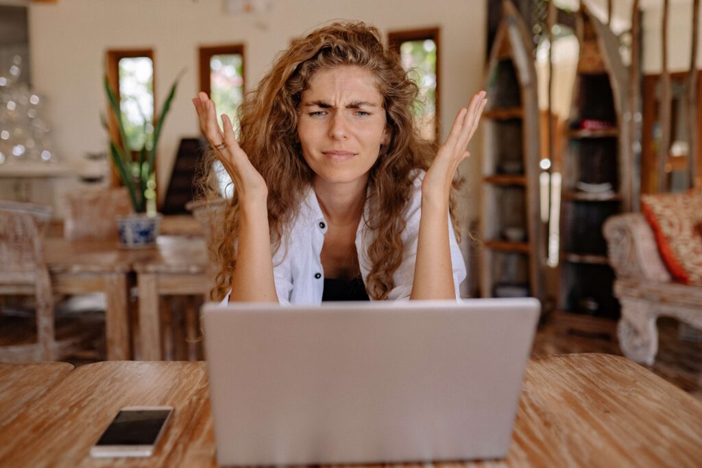 woman looking at the laptop looking frustrated
